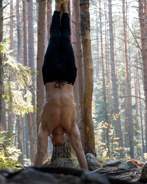 Man performing a controlled bodyweight exercise in a minimalist space.